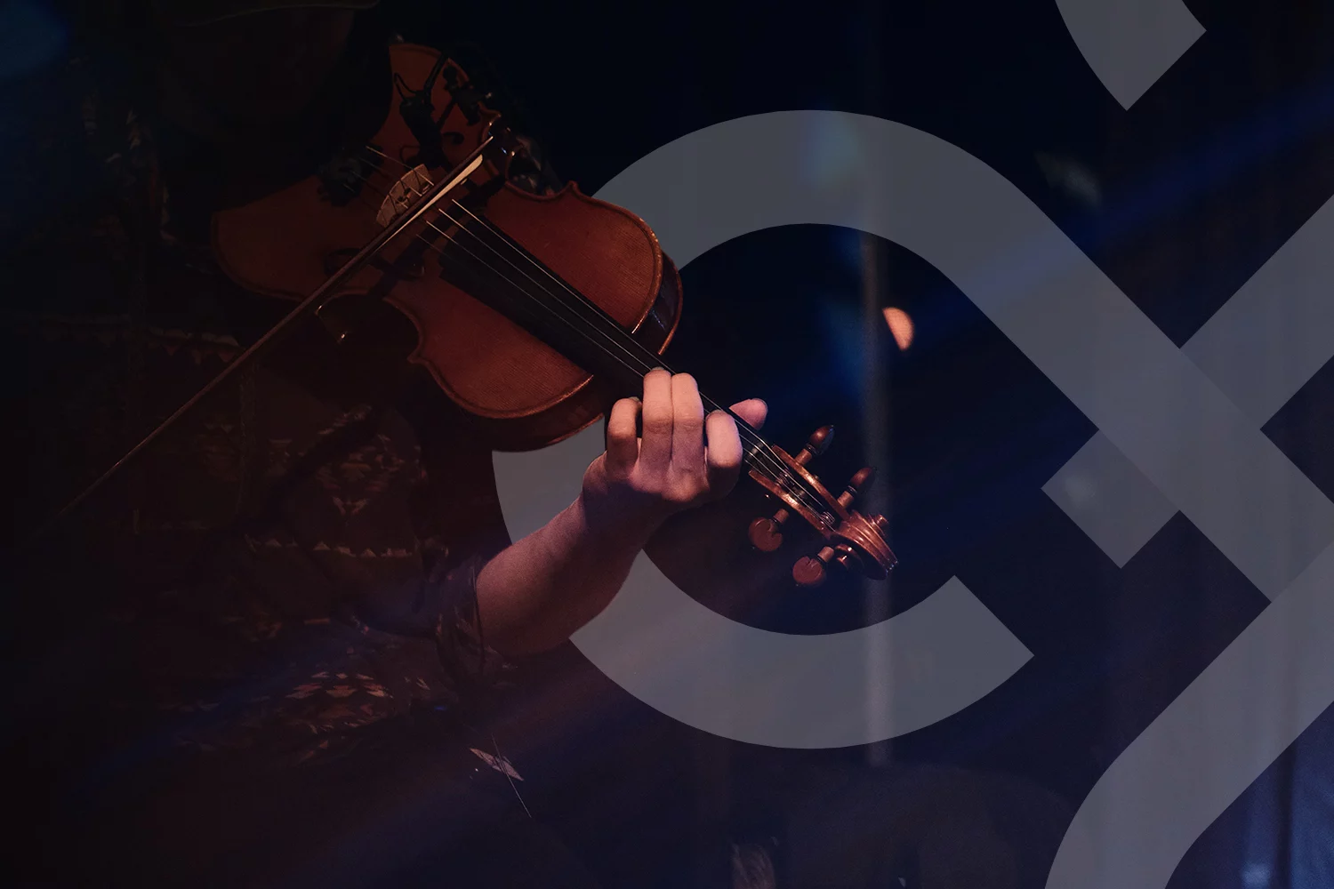 A musician playing the fiddle with the IDTANA logo interwoven.